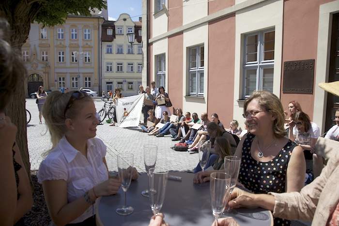 Die hinteren warten ohne Sekt oder Selters. Flashmob vor dem Verwaltungsgebäude der Stadtbau am Schillerplatz. Foto: Erich Weiß